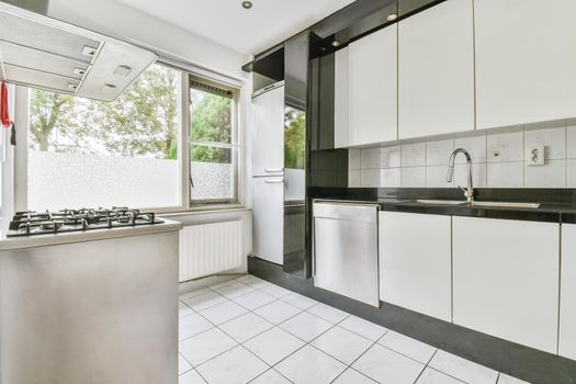 Interior of the light kitchen with modern appliances in a modern flat at daytime