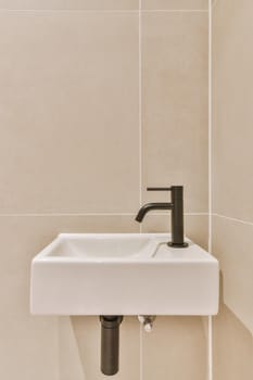 Stylish bathroom in a minimalist style in beige and black tones with a small sink