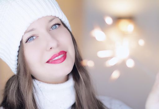 Christmas, people and winter holiday concept. Happy smiling woman wearing white knitted hat as closeup face xmas portrait.