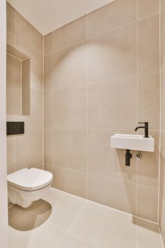 Stylish washroom in minimalist style in beige and black tones with hanging toilet