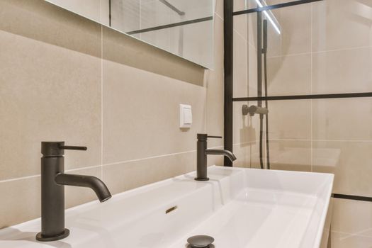 Stylish bathroom in a minimalist style in beige and black tones with a large sink