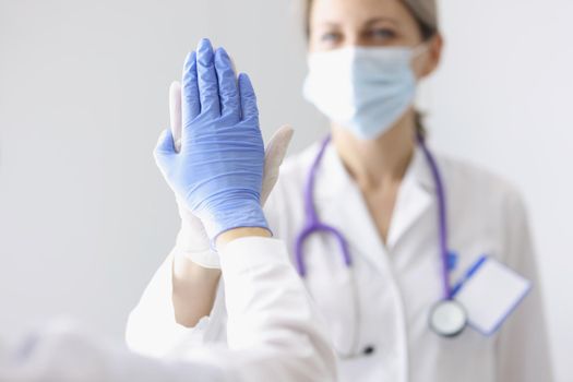 Portrait of medical coworkers give high five after successful surgery or diagnose to patient. Good job, well done gesture, celebrate win. Medicine concept