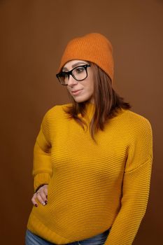 Attractive middle-aged Caucasian woman wearing a yellow sweater hat and glasses looks down to the side. Vision problem and people wearing glasses.