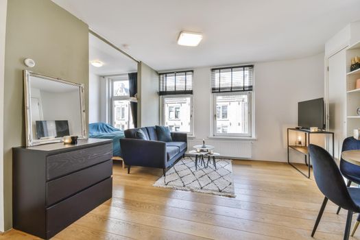 Delightful living room with black comfortable sofa with round coffee table
