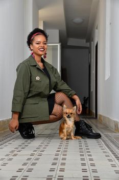 A pretty young African American confident woman in the stairwell of an old apartment building.