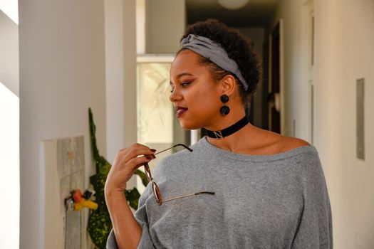 A pretty young African American confident woman in the stairwell of an old apartment building.