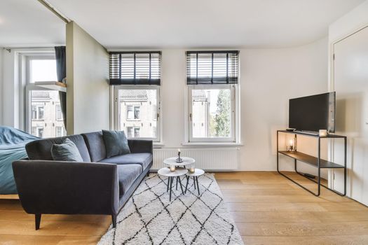 Delightful living room with black comfortable sofa with round coffee table