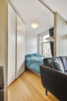 Delightful little bedroom with a soft bed covered with a blue fluffy bedspread