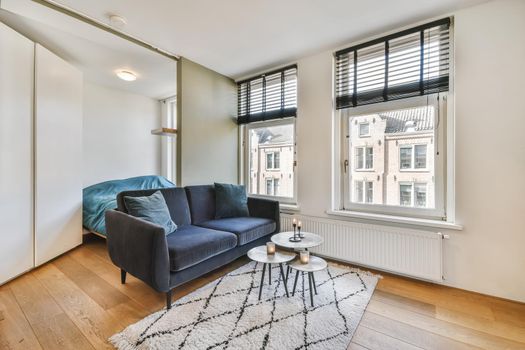 Delightful living room with black comfortable sofa with round coffee table