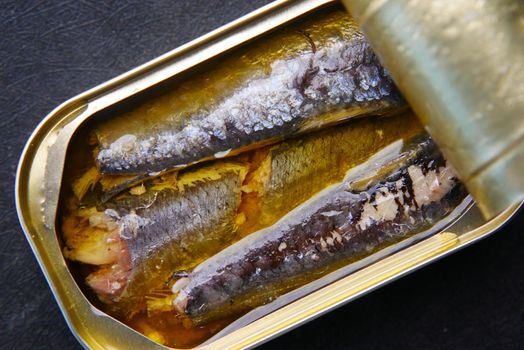 open tin of sardines on white tiles background