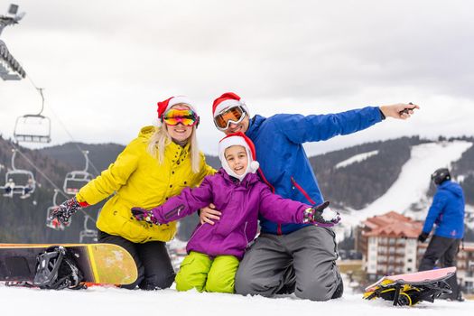 family in santa hats and snowboards.