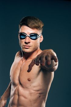 sports man with naked torso swimmer professional dark background. High quality photo