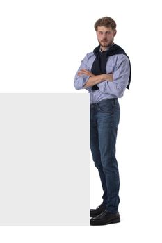 Young stylish casual business man behind a blank sign banner isolated on white background