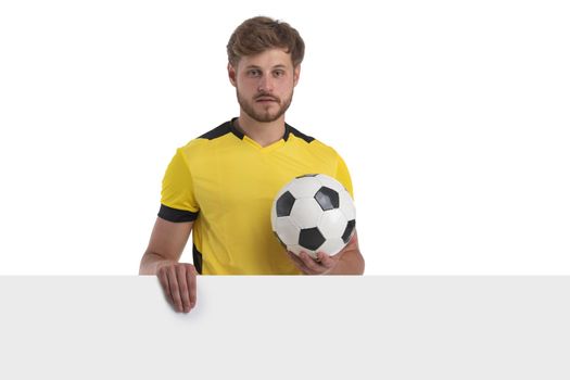 Soccer player in yellow jersey hold ball with empty banner isolated on white background
