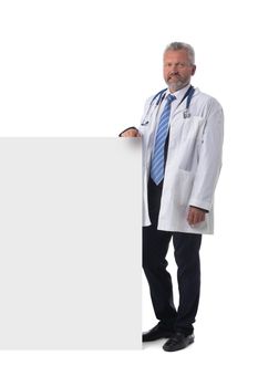Mature male doctor holding blank placard banner isolated on white background