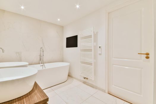 Luxurious bathroom with a large stylish bathtub and a TV opposite