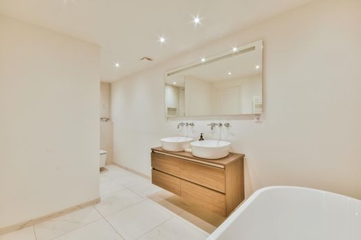 Luxurious bathroom with a beautiful hanging wooden chest of drawers with a sink