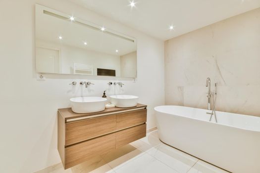 Luxurious bathroom with a beautiful hanging wooden chest of drawers with a sink