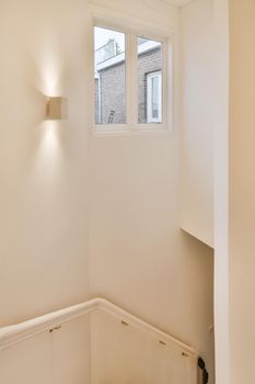 Convenient white stair handrails and window on the wall