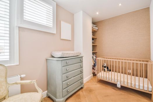 Cozy children's room in the daylight with a small crib
