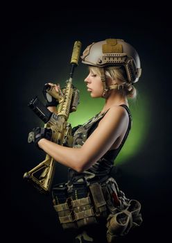 soldier girl poses with an automatic rifle