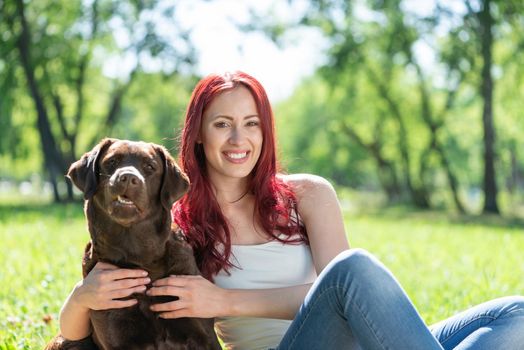 Woman in the park hugs a dog. Spend time with pets