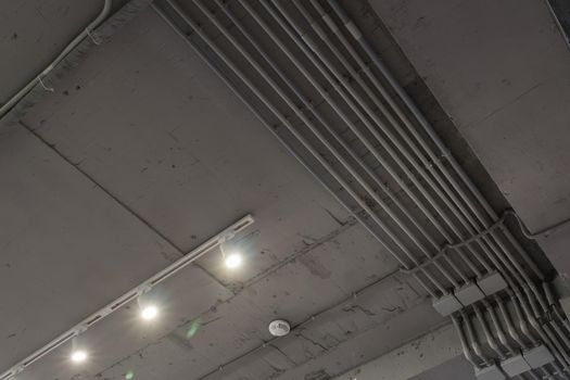 Interior architecture and ceiling design of industrial loft building decorated with modern lamps, glass windows and wall speakers