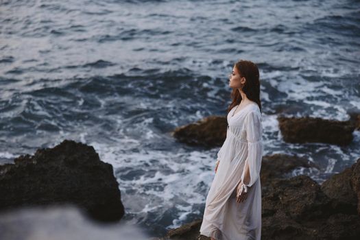 Woman in white dress nature rocky stones waves. High quality photo