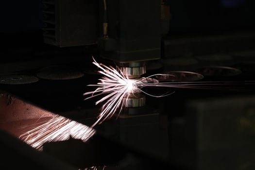 Bright sparks from metal turning, close-up. Laser cutting, mechanical engineering. Manufacturing complex parts
