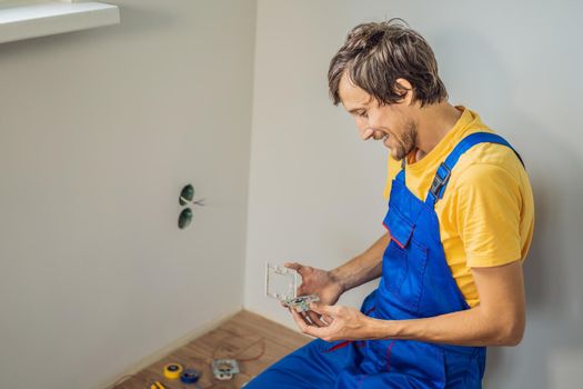 Master electrician installs a socket in the house.