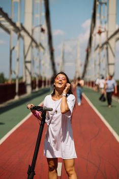 Young beautiful woman and an electric scooter, modern girl, new generation, electric transport, ecological transport