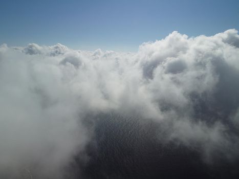 Footage B roll Aerial view drone flying above white clouds dense fog move quickly. Drone flies high back in blue sky through fluffy clouds. Beautiful foggy and cloudy slow moving Aerial view. Fog sea.