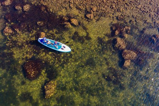 happy family of two, mother and son, enjoying stand up paddling during summer vacation.