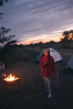 Young woman preparing food on the grill by the sea