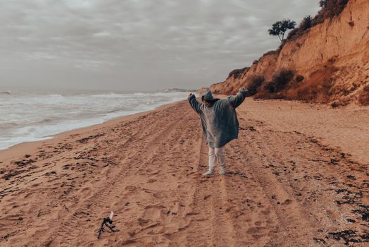 Woman on cold autumn seashore posing at camera