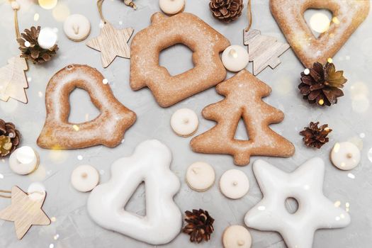 Banner for Christmas and New Year gingerbread stars, houses, Christmas trees, toys on a gray concrete background, Christmas lights bokeh in the foreground.