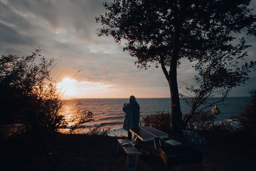 Woman takes a photo on a smartphone of the seascape