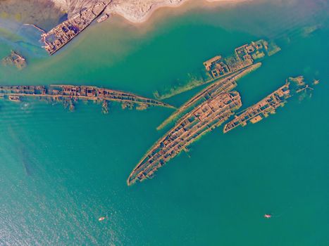 Abandoned broken shipwreck sticking out of the sea.