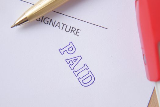 Paid invoice and Rubber Stamp on paper