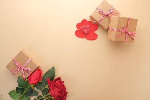 Top view of gift box, envelope and rose flower on yellow background .