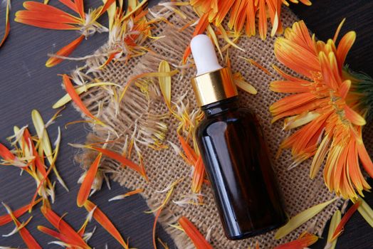 eucalyptus essential oils in a glass bottle and flower on table .