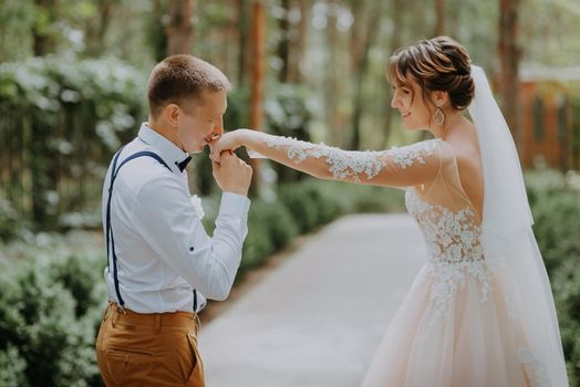 Sensual portrait of a young couple. Wedding photo outdoor. Wedding shot of bride and groom in park. Just married couple embraced