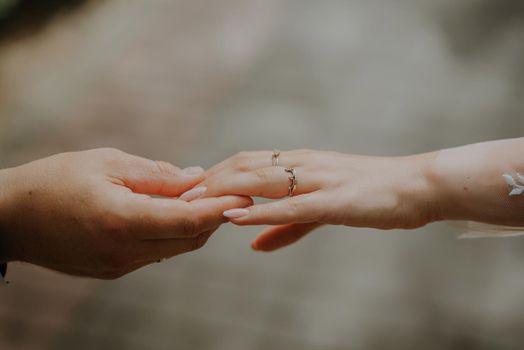 Wedding couple holding hands on sunset. Wedding rings. Man giving an engagement ring to his girlfriend