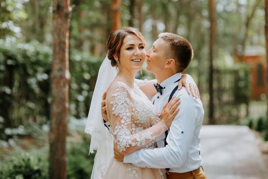 Sensual portrait of a young couple. Wedding photo outdoor. Wedding shot of bride and groom in park. Just married couple embraced