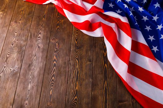 crumpled usa flag on flat textured wooden surface background.