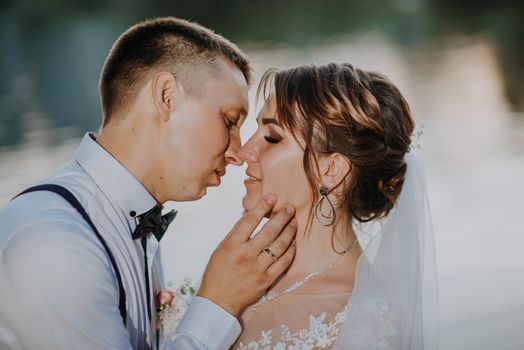 Sensual portrait of a young couple. Wedding photo outdoor. Wedding shot of bride and groom in park. Just married couple embraced