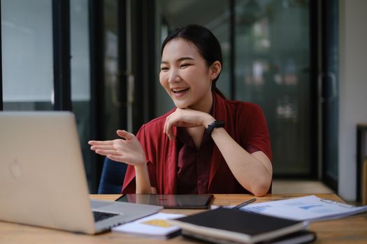 A happy woman has a business meeting with her team through video call In a cafe.