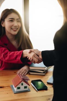 Estate agent and customer shaking hands after finished contract after about home insurance and investment loan.