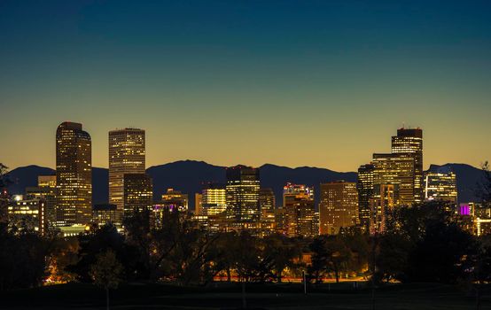 Illuminated Denver Downtown Towers and Front Range Mountains in a Background. Denver Colorado Skyline at Dusk