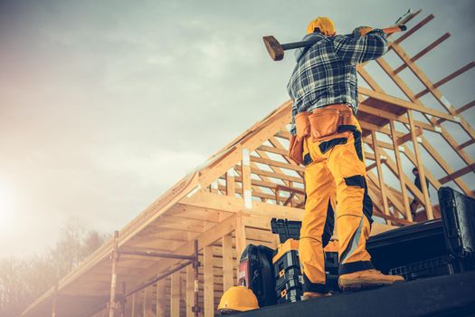 Strong Caucasian Construction Worker with a Large Hammer Ready For Tough Job Staying on His Pickup Truck Cargo Area. Construction Industry Theme.